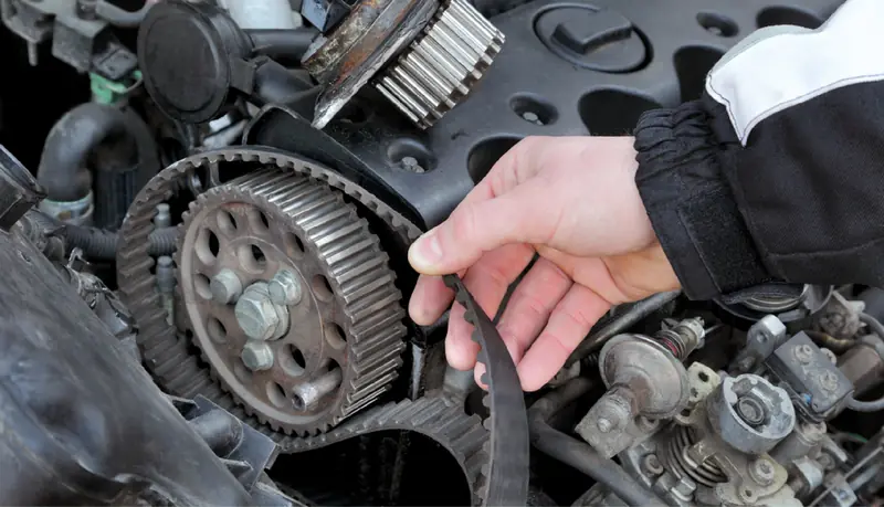 Mechanic checking a timing belt during a service